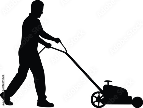 Silhouette of man mowing lawn with push mower grass
