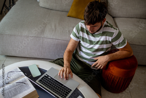 Boy participating in online education training class with teacher using laptop at home