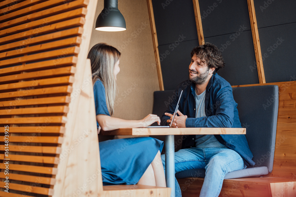 © BusinessClass by W61 - Smiling business people sitting with laptop and talking in office cubicle © BusinessClass by W61 - Smiling business people sitting with laptop and talking in office cubicle