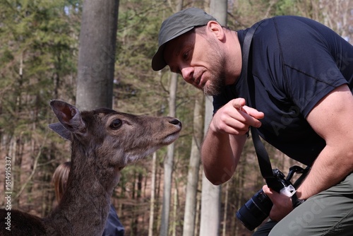 Canvas Print Man interacting with a fallow deer in nature