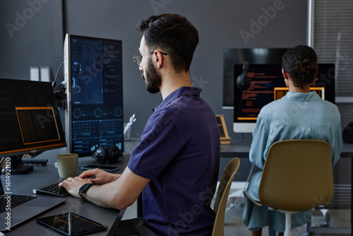 Computer programmers working on desktop PC in office