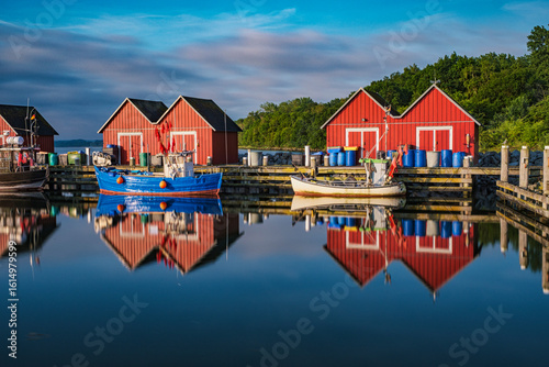 Reflection of the fishermen's cottages in the waters of the Weiße Wiek in Boltenhagen on the Baltic Sea at sunrise