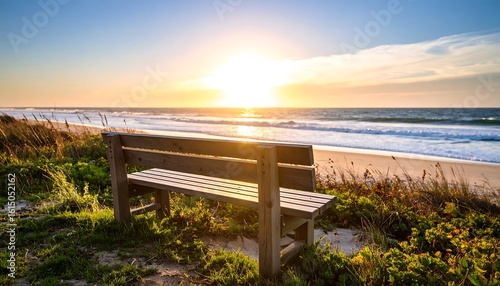 Fototapeta Naklejka Na Ścianę i Meble -  Serene sunrise over ocean, wooden bench on dune