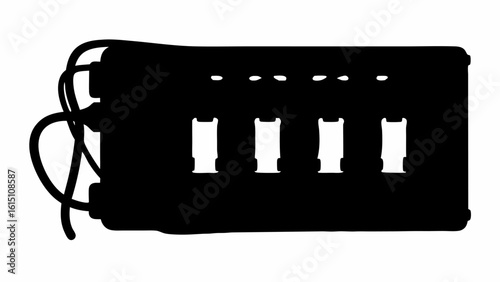 Silhouette of a rectangular electronic device with multiple ports and attached cables in a dark setting