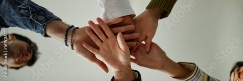 Bilde på lerret Diverse group of teenagers joining hands in teamwork gesture during counseling s