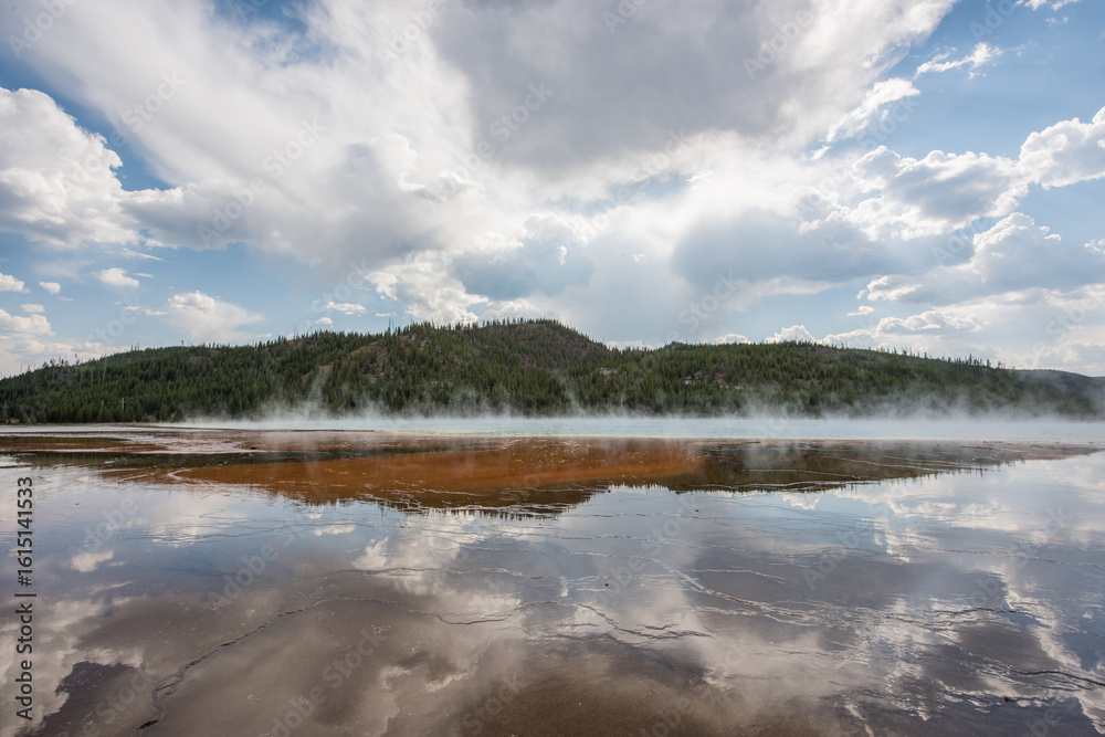 Obraz premium A wide shot of the Grand Prismatic Spring in Yellowstone National Park, Wyoming, showcasing its vibrant colors and the surrounding landscape.