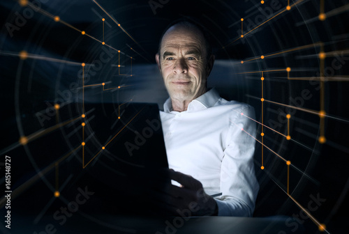 Businessman using laptop amidst illuminated dots at office