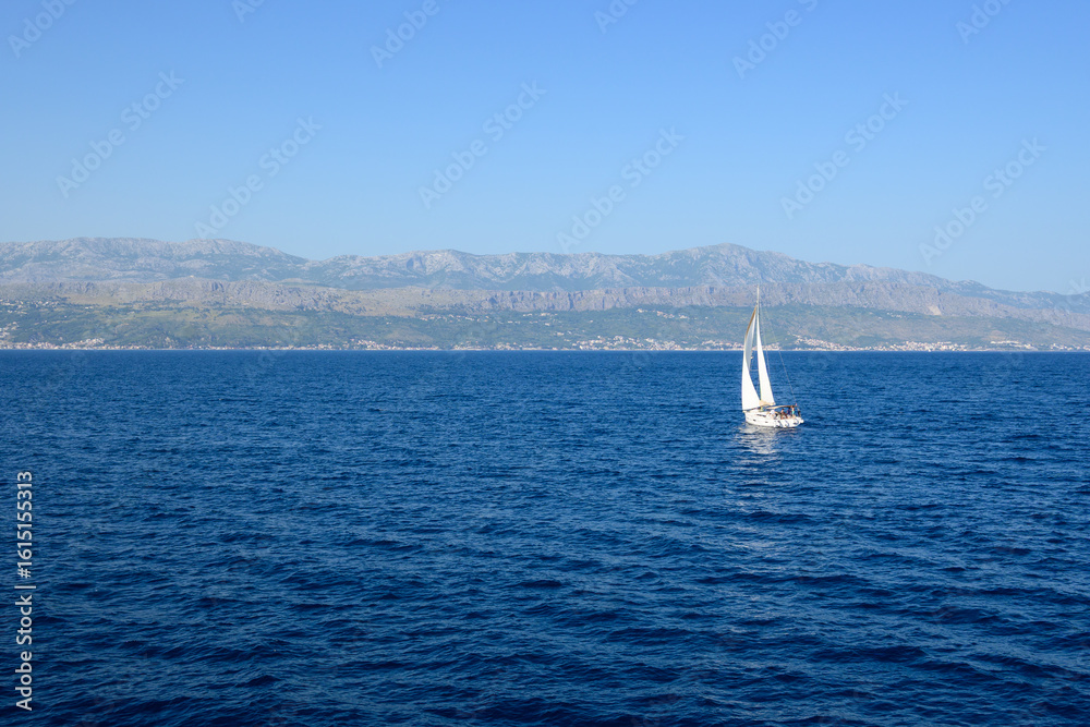 Fototapeta premium A yacht in the Adriatic Sea, with the Croatian coast in the background