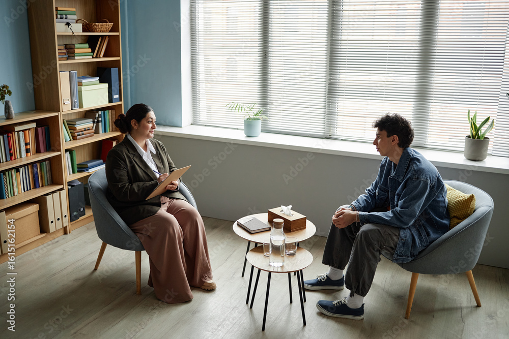 Φωτογραφία Female counselor conducting counseling session with male teenager sitting across