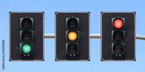 Traffic light sequence: green, yellow and red light with the sky as background.