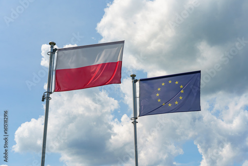 Polish and European Union flags against the blue, sunny sky, Poland