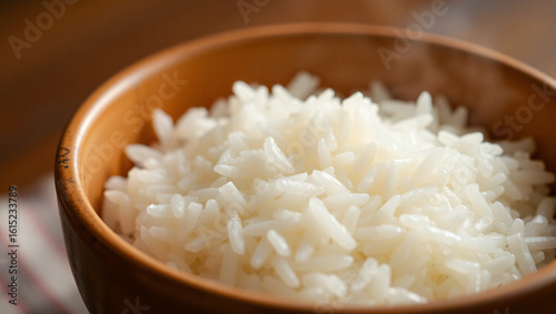 A freshly cooked bowl of white rice, with visible steam rising gently