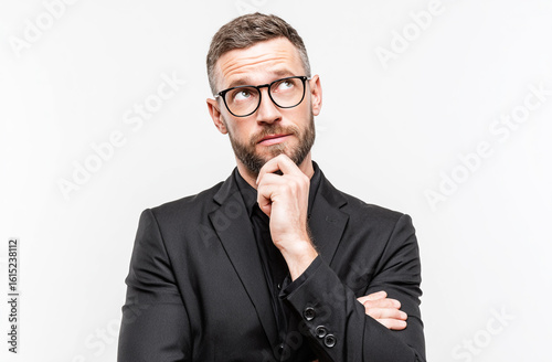 A portrait of an adult man in glasses, with short hair and a beard, wearing formal , is thinking about something isolated on a white background.