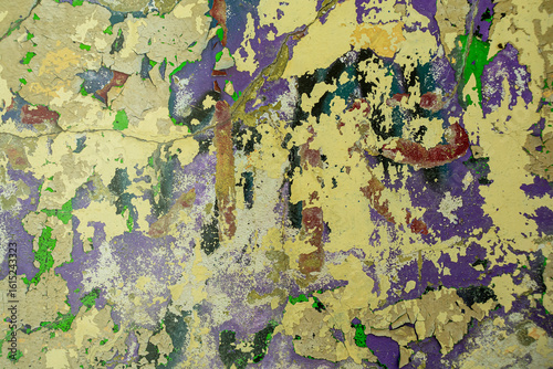 Abstract: crumbling graffiti on a city street wall. Colorful abstract background. Old, cracked, peeling paint serves as a background.