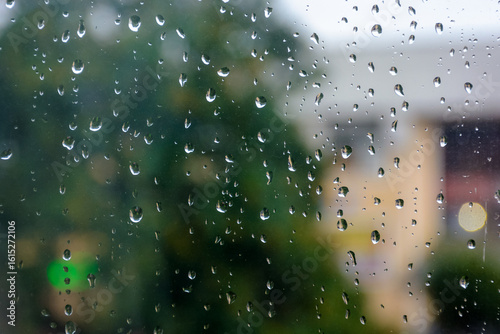 wet window background. rain drop on the glass surface. bad weather concept. urban landscape blurred in the distance
