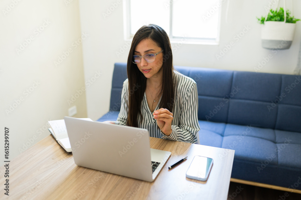 Female psychologist providing virtual therapy with laptop and notes Female psychologist providing virtual therapy with laptop and notes