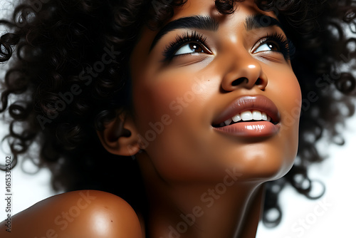 Close up portrait of a young black woman with curly hair looking upwards