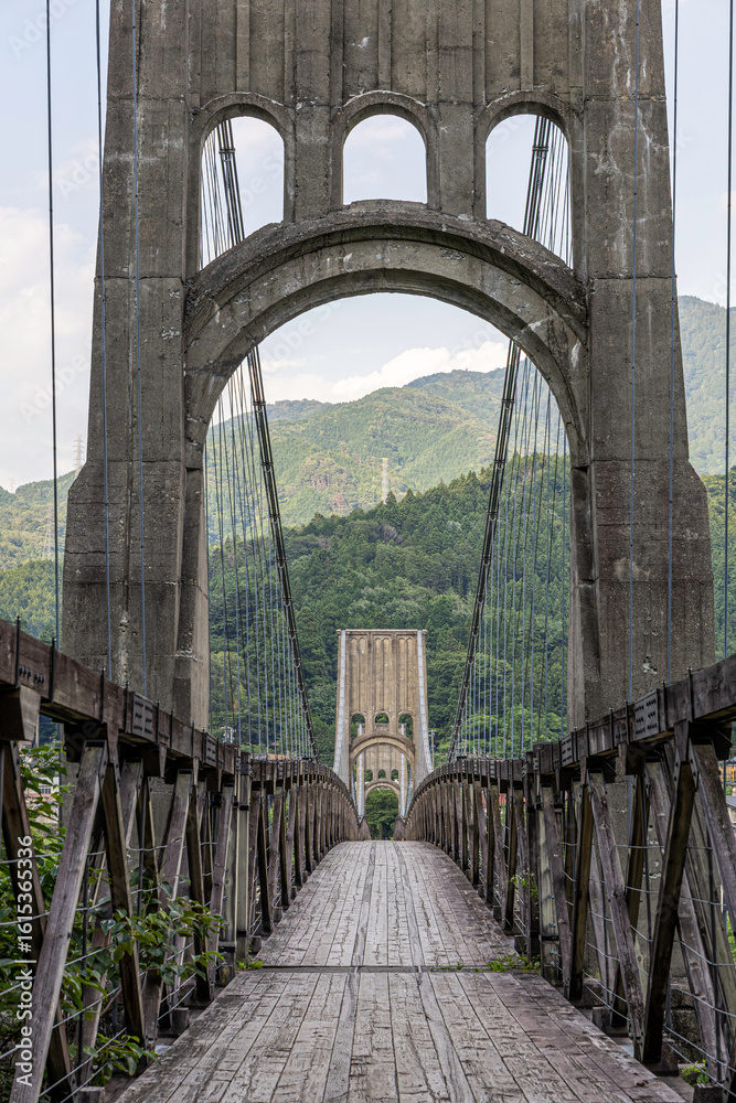 Fototapeta premium 歴史的な木造吊り橋と山の風景が美しい長野県の桃介橋