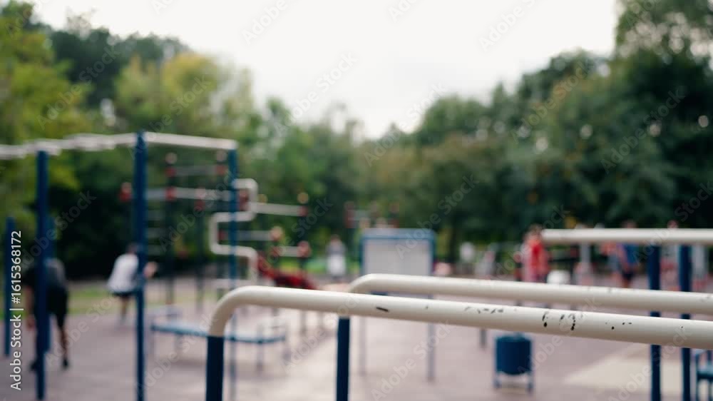 Blurred View of People Exercising in an Outdoor Gym in a Park. Adults Engaging in Various Fitness Activities. Promoting Health, Wellness, and Community Recreation. Blurred View of People Exercising in an Outdoor Gym in a Park. Adults Engaging in Various Fitness Activities. Promoting Health, Wellness, and Community Recreation.