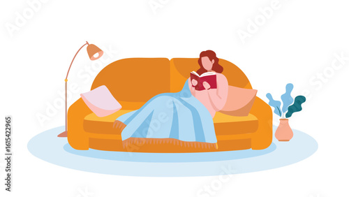 Woman reading a book while lying on a couch with a blanket next to a lamp and a vase of plants
