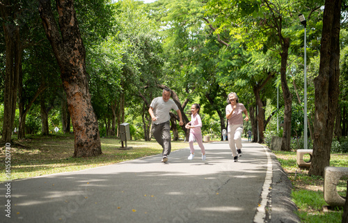 Wallpaper Mural Happy Asian grandparents and granddaughter running joyfully together in a park Torontodigital.ca
