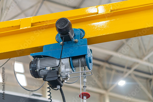 Cuadro en lienzo Yellow gantry crane in an industrial setting, with blue and black motorized hois