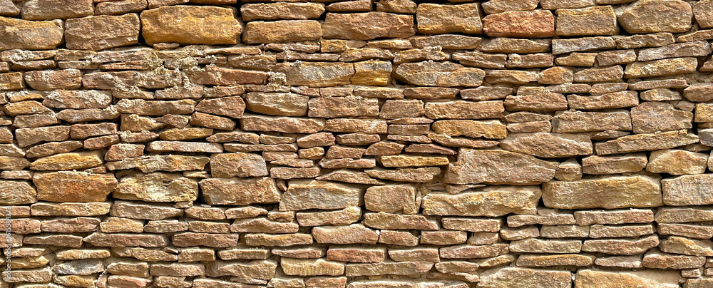 Obraz premium Old stone wall showing textured brickwork creating rustic background