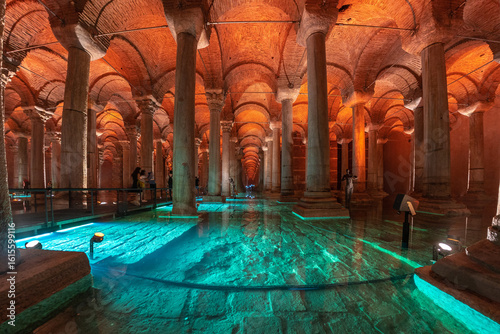 Basilica cistern illuminated with turquoise water reflecting the ancient columns in istanbul, turkey