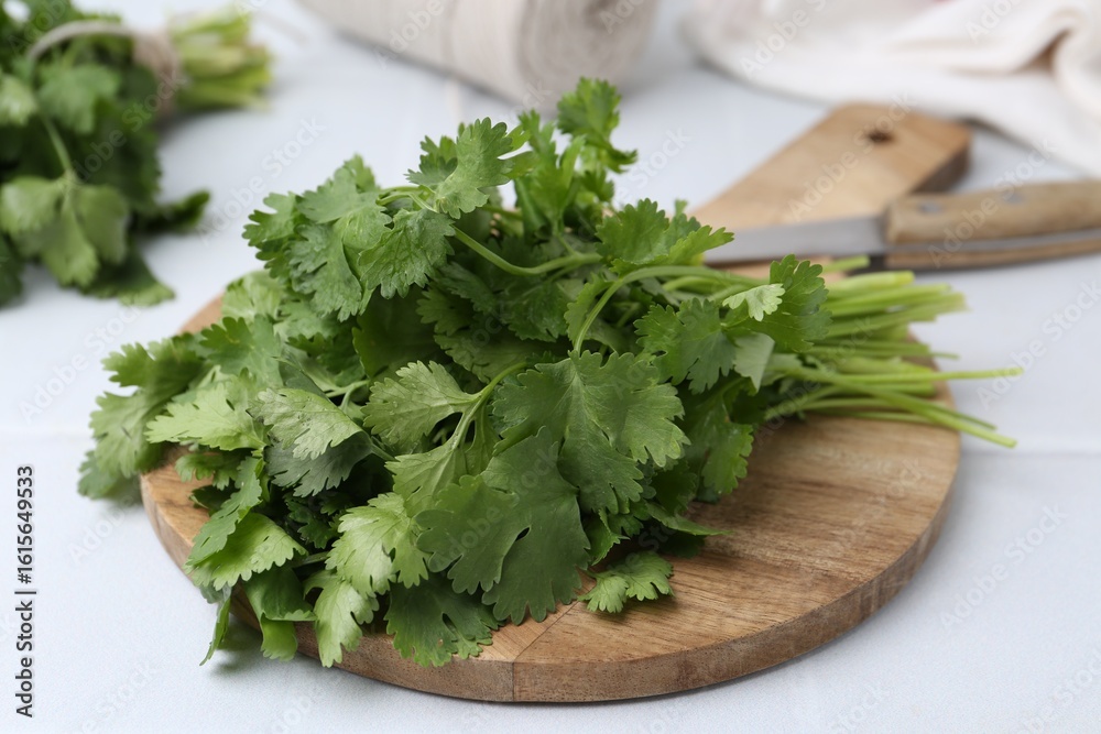 Cutting board with fresh cilantro and knife on white table, closeup Cutting board with fresh cilantro and knife on white table, closeup