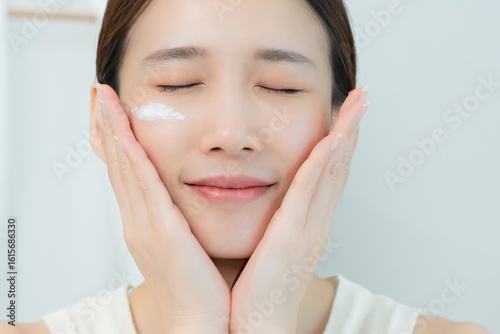 Beautiful Asian woman smile use cream for good skin. face of a healthy woman apply cream and makeup. Advertisement for skin cream, anti-wrinkle, baby face, whitening, moisturizer, tighten pores serum