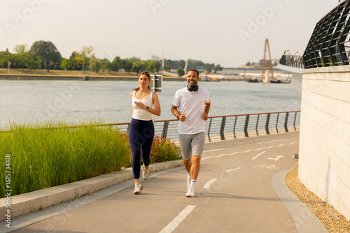 Couple jogging along the ri...