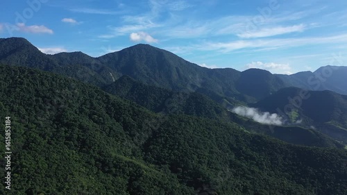 Aerial view of a mountainous and preserved region of the Atlantic Forest, a tropical rainforest in Rio de Janeiro, Brazil. The beauty and biodiversity are the highlights.