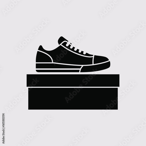 Black silhouette of a sneaker on top of a black box
