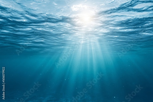 Ocean waters glow under bright sun  with light rays streaming into depths. Ideal for nature and aquatic projects.