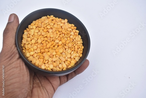 Man holding bowl of Split pigeon peas or Toor dal .