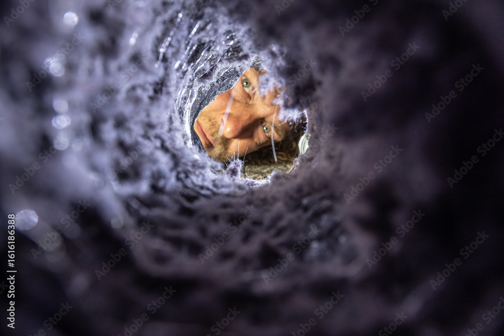 Ταπετσαρία Man inspecting a dryer vent with a flashlight, checking for lint buildup and blockages