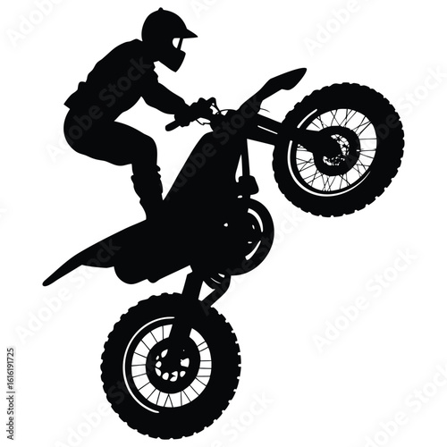 Silhouette of a motorcycle rider doing a wheelie on a dirt bike