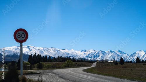 speed limit sign on the path with snow mountain view