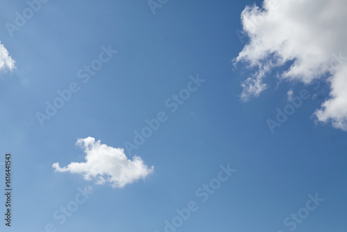 Photography Clear blue sky with fluffy white clouds scattered across the horizon, creating a