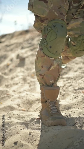 A soldiers sturdy boots tread purposefully through the expansive sandy terrain under the bright blue skies above