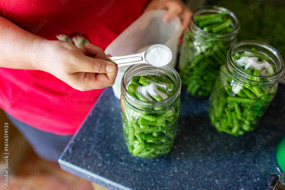 Foto adding salt to jarred green beans