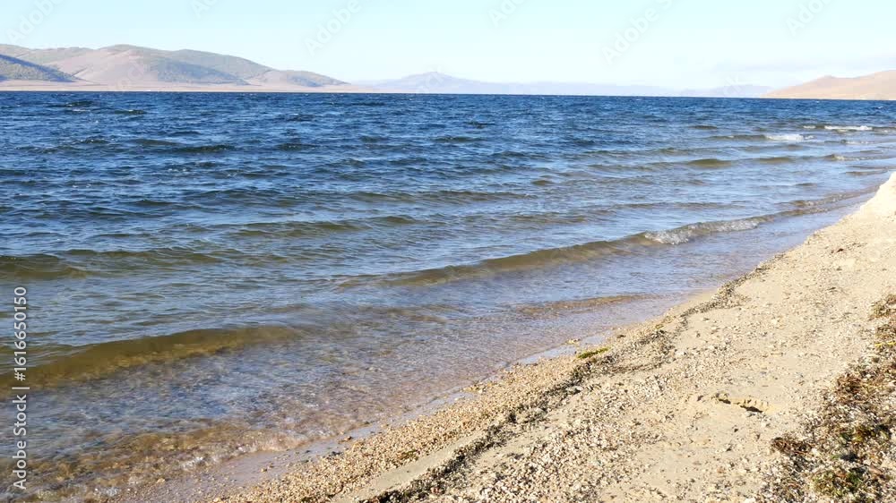 Terkhiin Tsagaan nuur lake in Mongolia on a sunny autumn evening, picturesque cold turquoise waves rolling onto the sandy shore.
Terkhiin Tsagaan nuur lake in Mongolia on a sunny autumn evening, picturesque cold turquoise waves rolling onto the sandy shore.