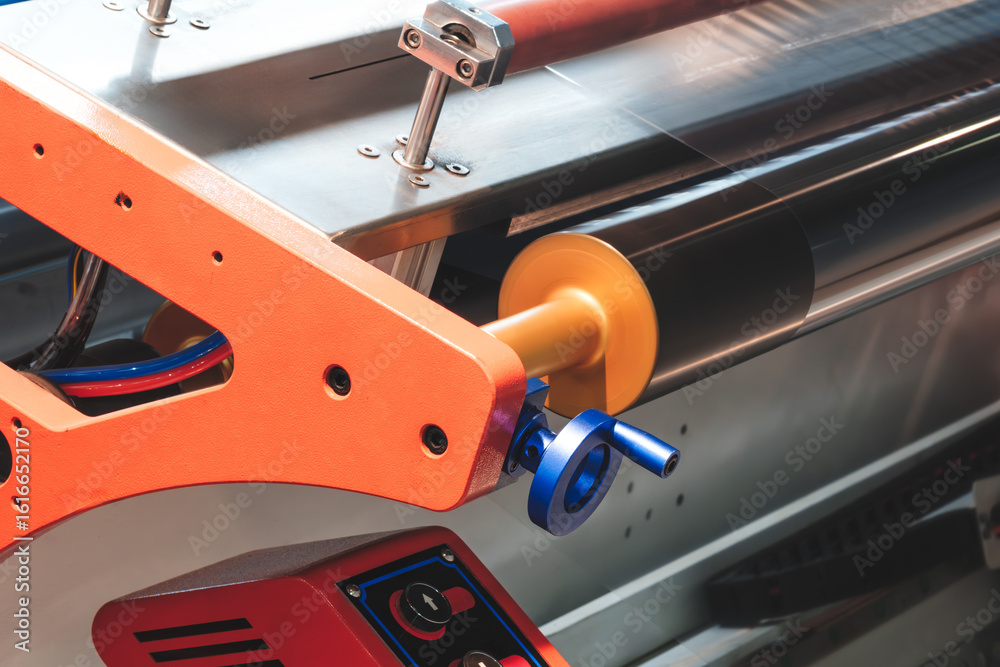 Naklejka premium roll of plastic polyethylene film is cut by a food packaging machine. Industrial concept background.