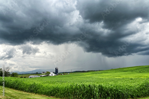Summer rain storm over farm and mountains - rainy weather