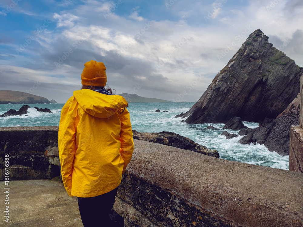 Φωτογραφία Girl tourist in yellow jacket and hat explore stunning Dunquin Pier area in county Kerry, Ireland