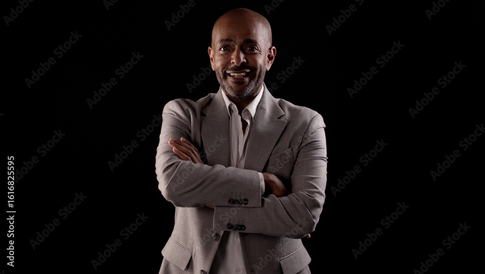 Portrait of confident african american businessman smiling with crossed arms on black background Portrait of confident african american businessman smiling with crossed arms on black background