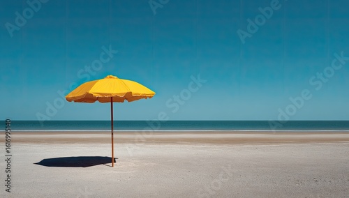 A solitary yellow beach umbrella on a pristine sandy shore under a vibrant blue sky