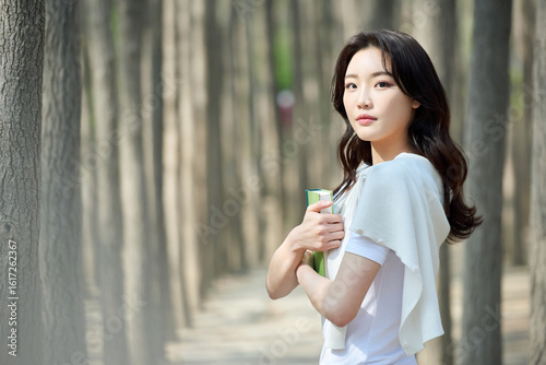 Wallpaper Mural Young Asian Female Student Holding Books in Spring Forest Torontodigital.ca