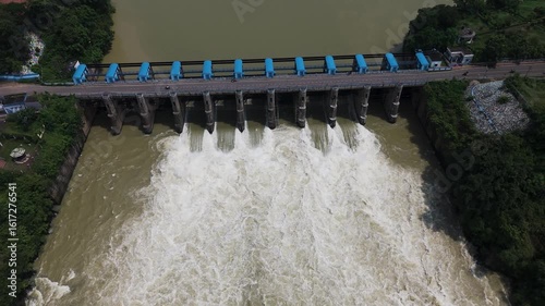 Drone view of river water gushing from a dam after heavy monsoon rains.