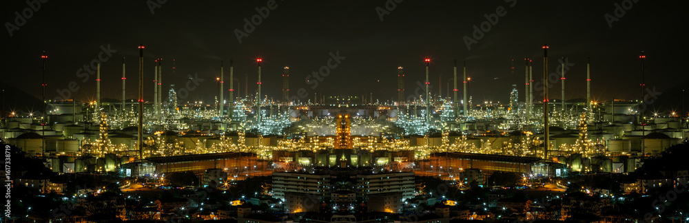Fototapeta premium Large industrial oil refinery complex with multiple tall chimneys and metal structures background at night.